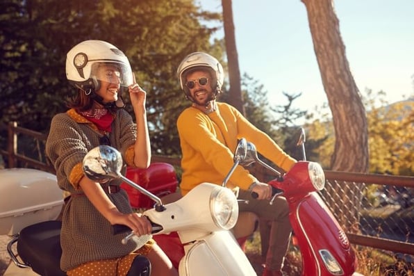 Couple on mopeds enjoying their summer holiday