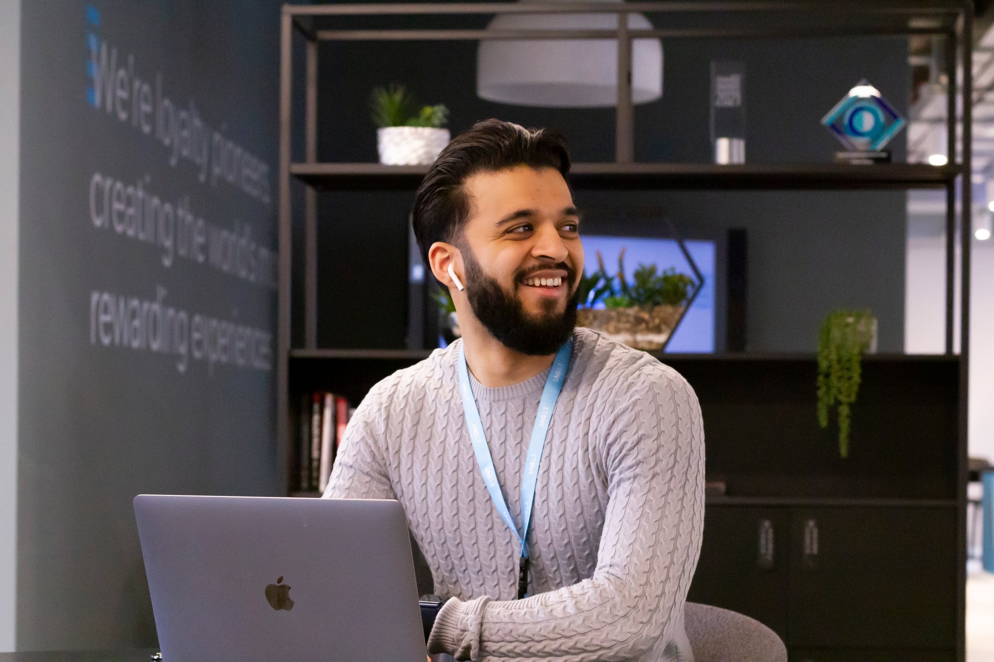 One of our colleagues Zain smiles at his laptop in the office